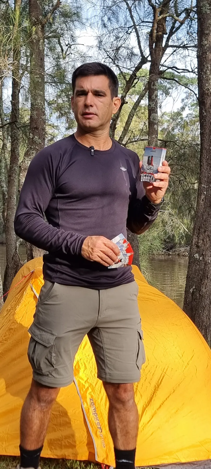 João, founder of Gotta Go There, holding the first Hiking Edition in front of a tent